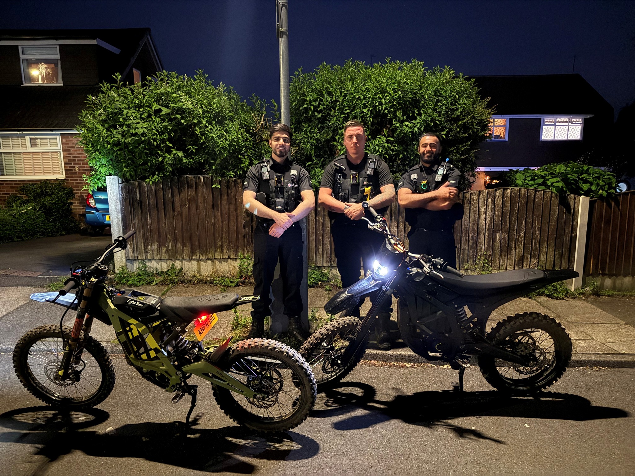 Three police officers stood next to the e-bikes that they seized.