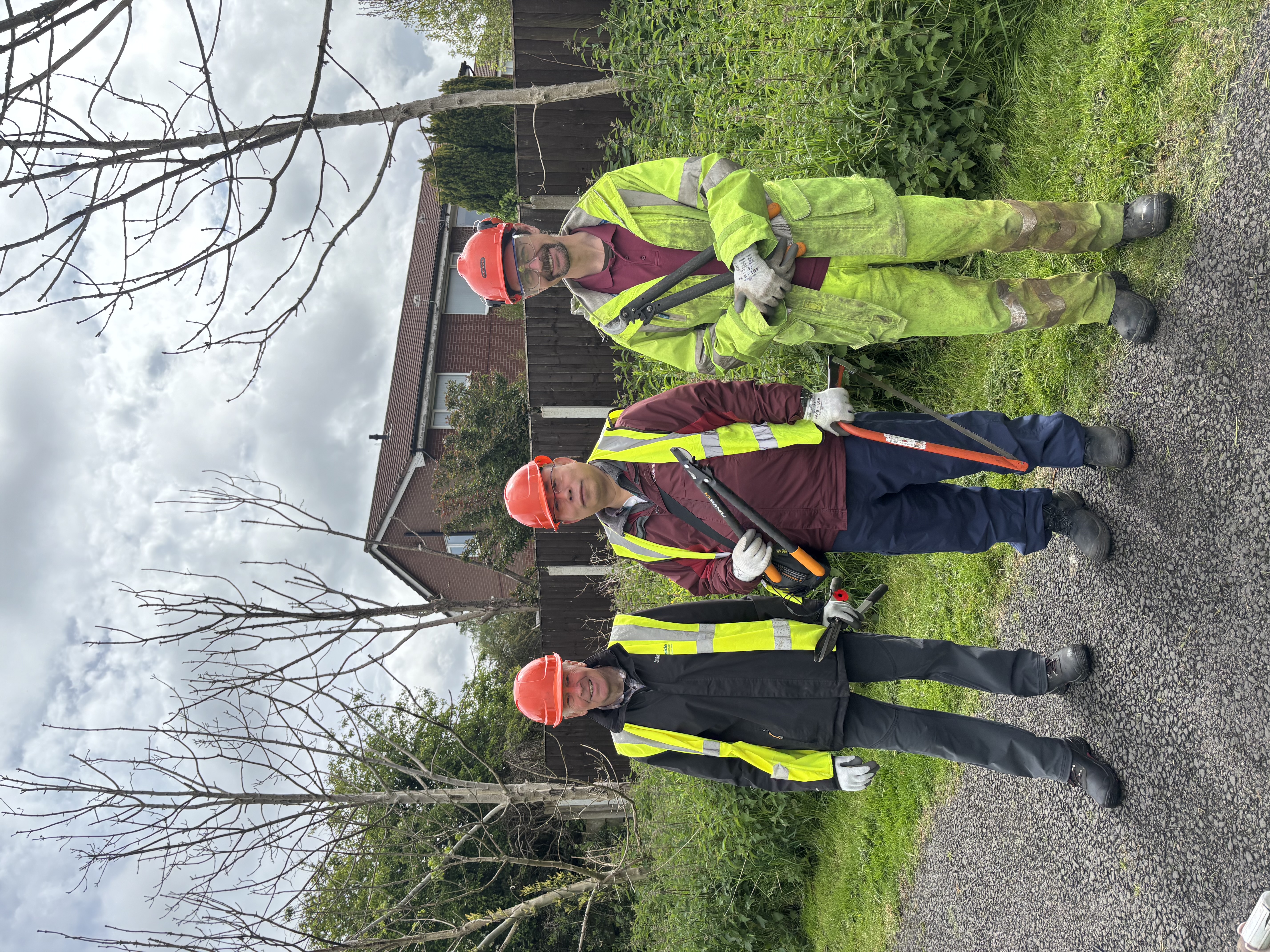 Volunteers from Tameside Council's Greenspace team with hard hats and spades.